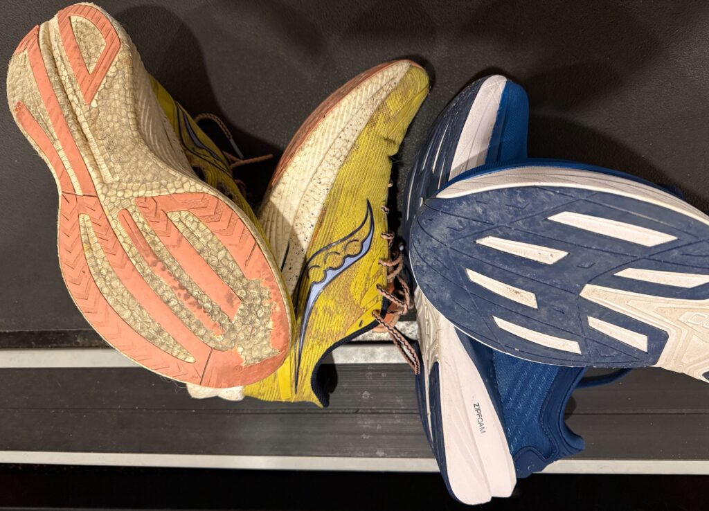 Worn running shoes showing tread wear comparison and mileage tracking